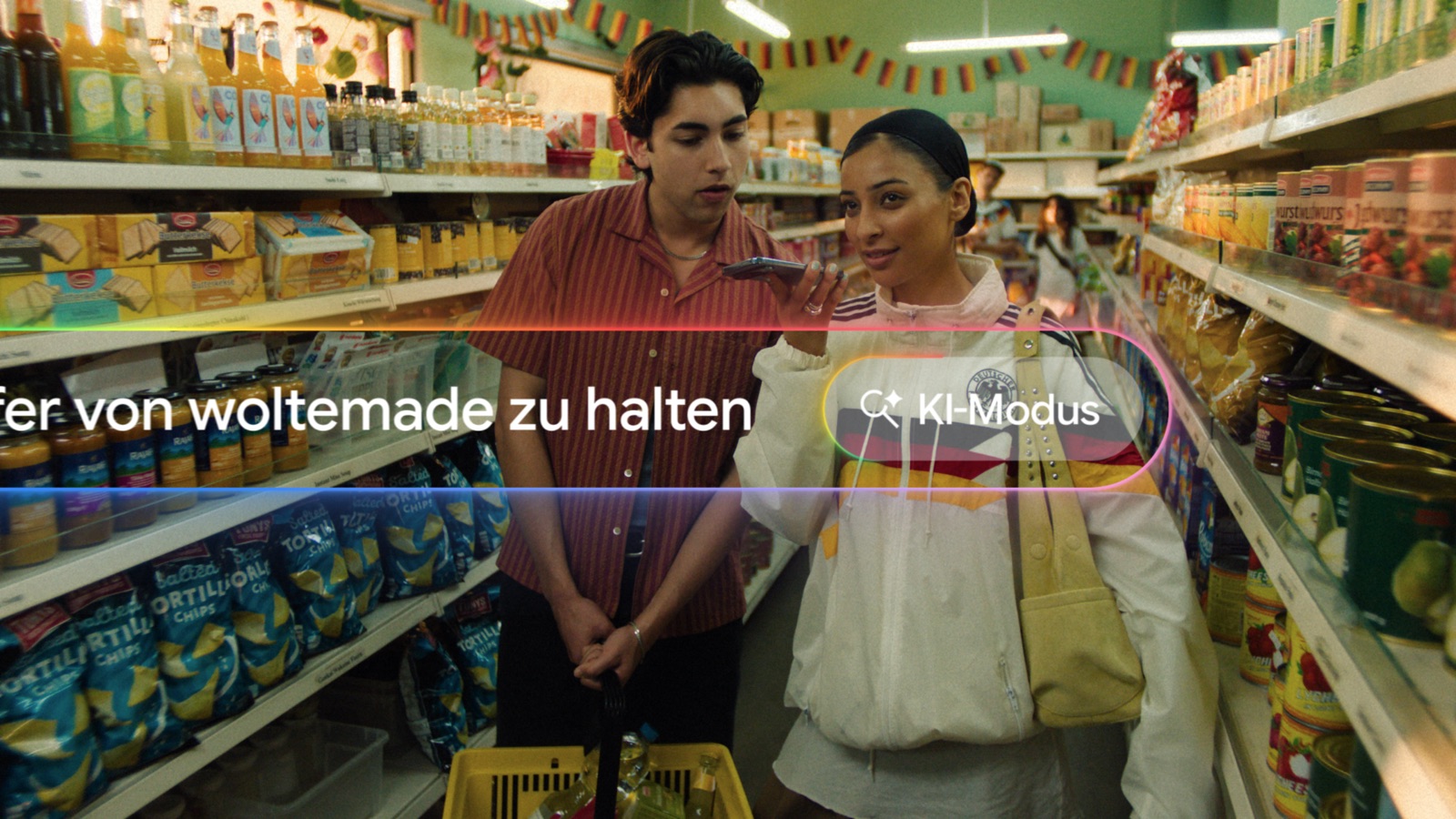 Two fans in a supermarket aisle asking Google a question out loud, the KI-Modus pill overlaid